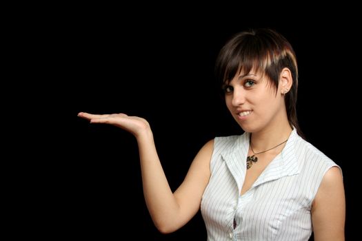 The young girl holds something in a hand, is isolated on a black background