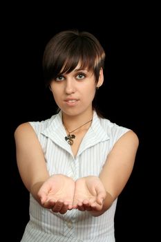 The young girl holds something in a hands, isolated on a black background