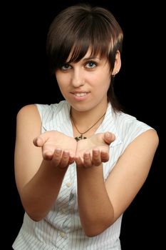 The young girl holds something in a hands, is isolated on a black background