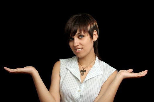 The young girl holds something in a hands, isolated on a black background