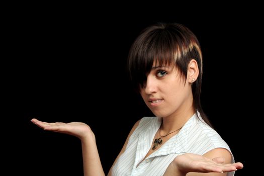 The young girl holds something in a hands, isolated on a black background