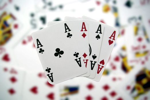 Poker cards showing a four-to-ace combination on a blurry background