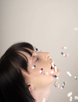 Young woman with colours pills