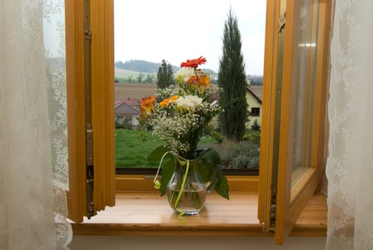 opened wooden window with bunch of flowers in jug