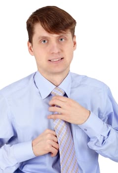 One young man arranges his tie on a white background