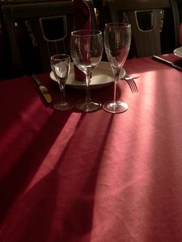 The goblets on table with crimson tablecloth.