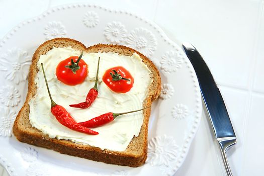 Food arranged into a smiley face on sandwich
