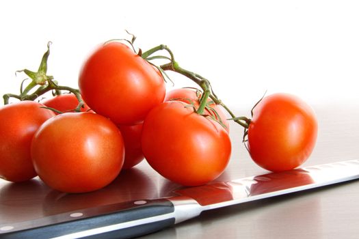 Fresh ripe tomatoes on stainless steel counter with white background