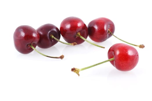 Five cherries isolated on a white background.