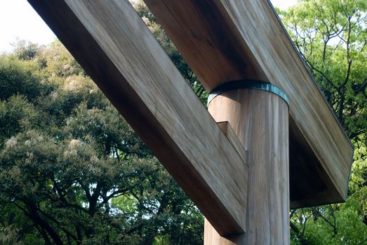 Japanese Torii Gate. Marks the entrance to a Shinto shrine. Angled corner. wood texture against greenery