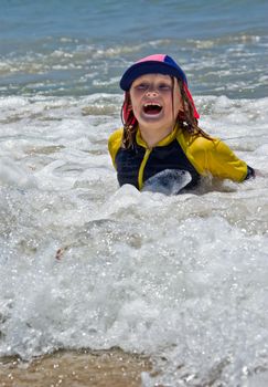 a young girl plays in the waves at the beach