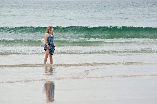 young girl looks back when not sure of going into water