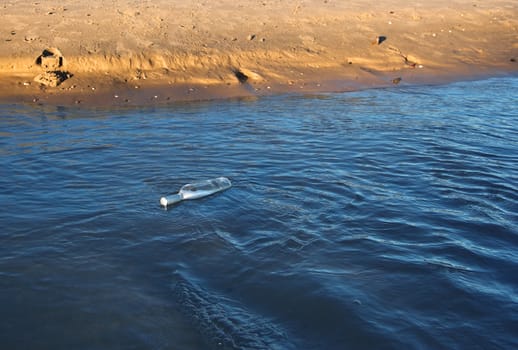 an sos message in a bottle at the beach