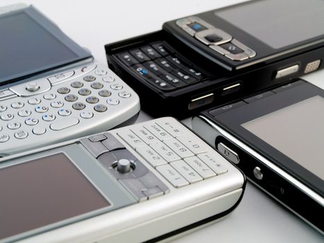 Stack Pile of Several Modern Mobile Phones PDA Cell Handheld Units Isolated on White Background