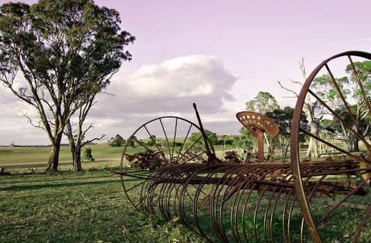 an old plow lay forgotten and neglected in the farmers paddock