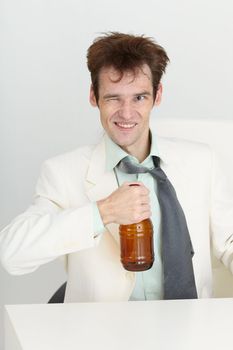 Cheerful guy in a white jacket with a bottle of beer in his hand