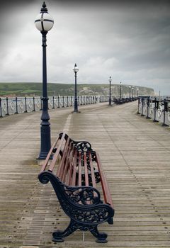 A lonely and bleak image of a deserted pier on a dull overcast day