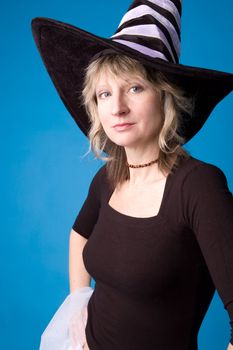 Woman in the witch's hat on blue background.