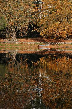 boat and reflection in autumn scene