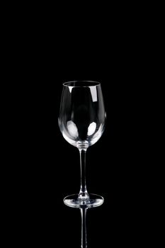 Empty wine glass on black background with reflection
