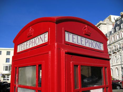 Classic British telephone box in a city setting against a rich blue sky