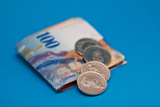 Swiss Franc Bills and Coins on blue background