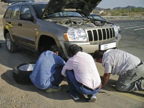 Team of men changing a wheel in the desert