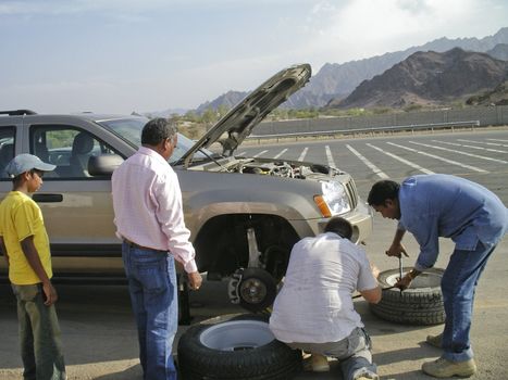 Team of men hanging a wheel in the desert