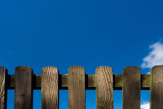 Wood fence against deep blue sky