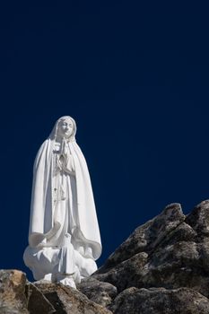 Statue of the Virgin Mary (Our Lady of Fatima) with deep blue sky.