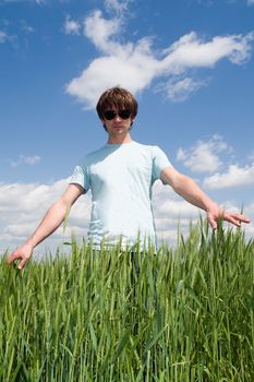 young man touches the hand green ears of rye