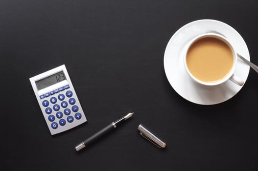 business breakfast in the office on black desktop with calculator pen and glasses