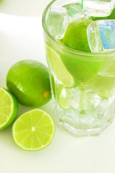 Caipirinha cocktail with green lemon and ice cubes