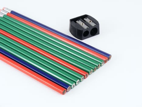 Red, green and blue pencils and a hand sharpener.