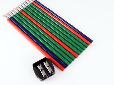 Red, green and blue pencils and a hand sharpener.
