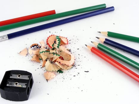 Red, green and blue pencils and a hand sharpener.