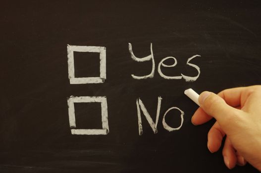 vote yes or no written on chalkboard or blackboard