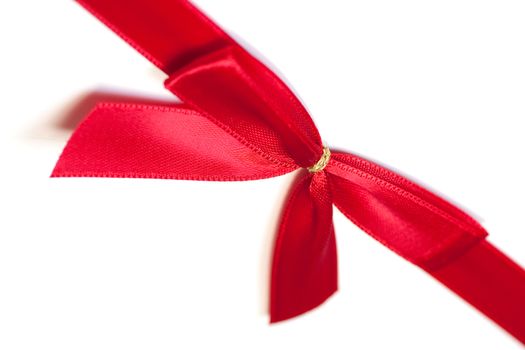 A red ribbon, tied in a bow on a white background. 