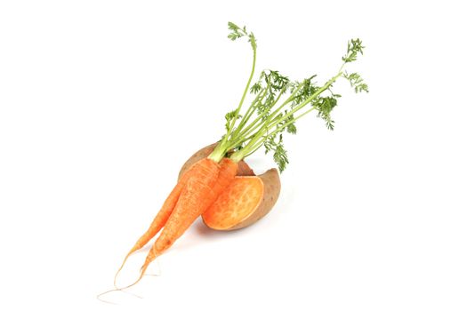 Sweet Potato cut in half with a bunch of raw carrots on a reflective white background