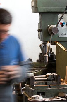 Worker and old gear in vintage workshop