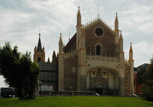 historical cathedral in madrid with grass, trees and sky with cloud