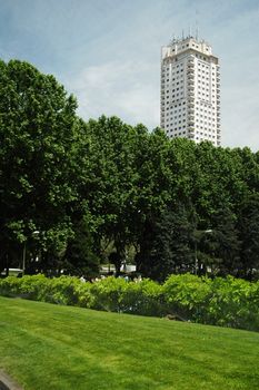 madrid white skyscraper behind trees of park