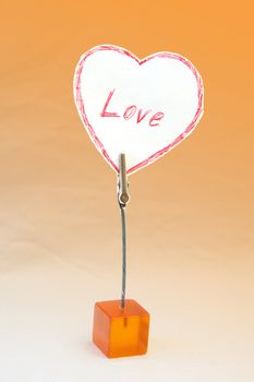                            Heart-shaped reminder in an orange cube holder    