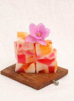 Pieces of jelly lying on a wooden desck, decorated with a violet