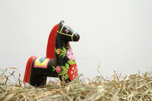 Hohloma horse stasnding in hay on a white background