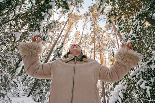 Happy middle-aged women having fun on winters day in forest.