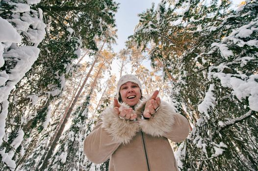 Happy middle-aged women having fun on winters day in forest.