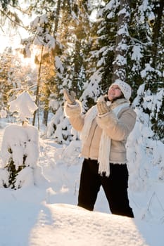 Happy middle-aged women having fun on winters day in forest.