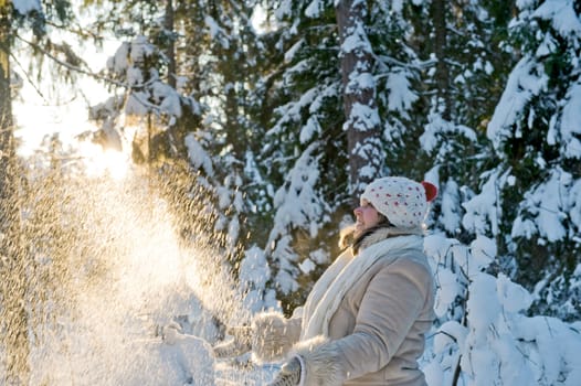 Happy middle-aged women having fun on winters day in forest.