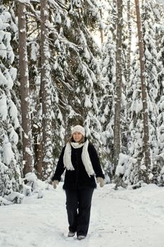 Happy middle-aged women having fun on winters day in forest.